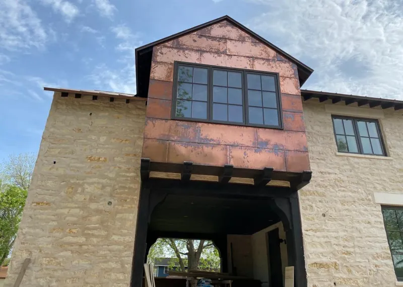 Copper metal panel facade on a stone building for Skylight Installation in Youngsville