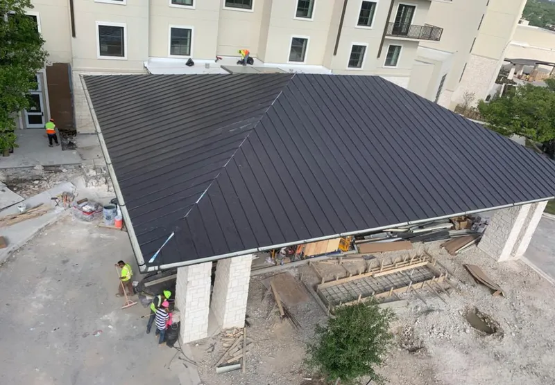 Metal roofing installation team working on a commercial building in Youngsville